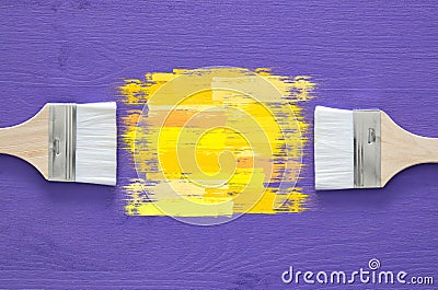 paint brushes and yellow stroke on purple background Stock Photo