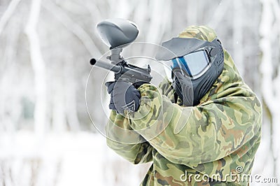 Paintball player with marker at winter outdoors Stock Photo