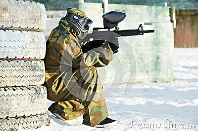 Paintball player with marker at winter outdoors Stock Photo