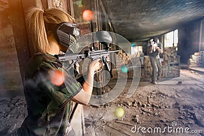 Paintball player shooting in opposite player Stock Photo