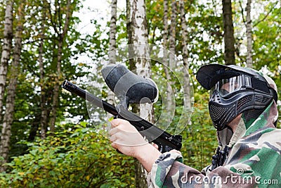 Paintball player shoots aside in forest Stock Photo