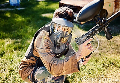 Paintball, target practice or male with gun in shooting game playing with on war battlefield mission. Army training or Stock Photo
