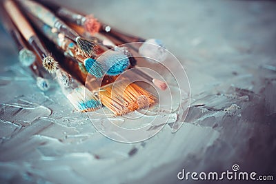 Paintbrushes on artist canvas covered with oil paints Stock Photo