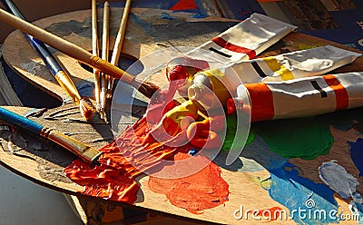 Paintbrushes, artist palette, oil paints on desk in painter studio Stock Photo