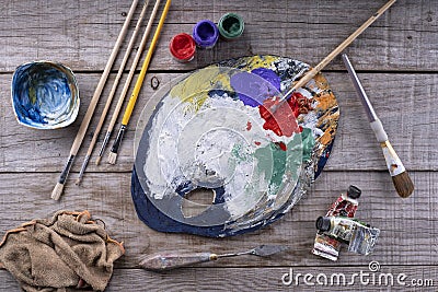 Paintbrushes, artist palette, oil paints on desk in painter studio. Close up Stock Photo