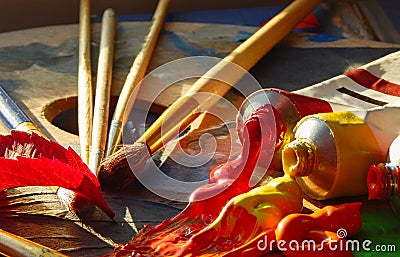 Paintbrushes, artist palette, oil paints on desk in painter studio Stock Photo