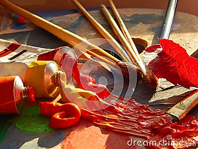 Paintbrushes, artist palette, oil paints on desk in painter studio Stock Photo