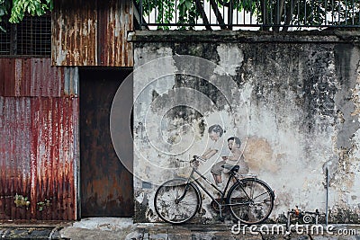 Painted Girl and Boy Riding Real Bicycle on The Old Concrete Wall from The Street of George Town. Penang, Malaysia Editorial Stock Photo