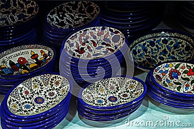 Painted souvenir plates on the counter in the store of Jerusalem, Israel. National ornament on a plate with blue edging Stock Photo