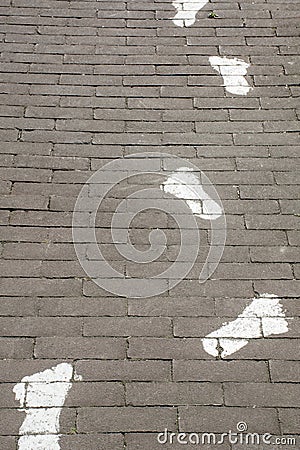 Painted white footprints on pavement Stock Photo