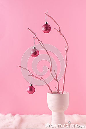 Painted wooden branch with glittering pink ornament balls in white vase on a fluffy fur and pastel pink background. Christmas Stock Photo