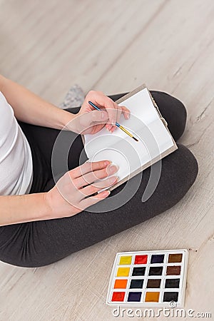 Painter holds a brush in her hand and draws with watercolor pain Stock Photo