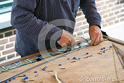 Painter man makes stained glass. Stock Photo