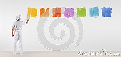 Painter man with paint brush painting color samples isolated Stock Photo