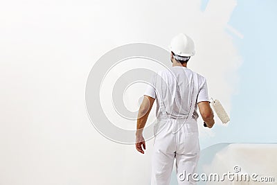 Painter man at work with a paint roller, wall painting Stock Photo