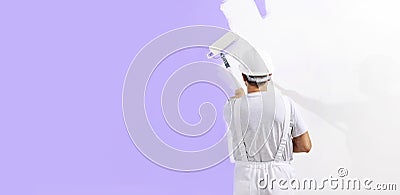 Painter man at work with a paint roller, wall painting concept, web banner and copy space template Stock Photo