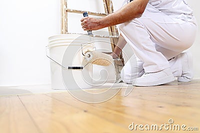 Painter man at work with a roller, bucket and scale, bottom view Stock Photo