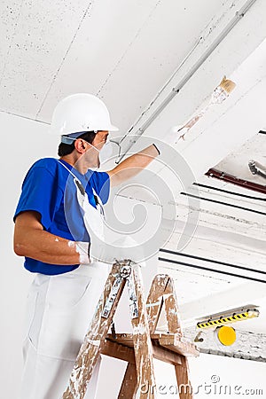 Painter painting ceiling with brush Stock Photo