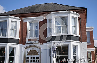 Painter on top of ladder painting white the facade of Pearl Hotel in Peterborough. Editorial Stock Photo