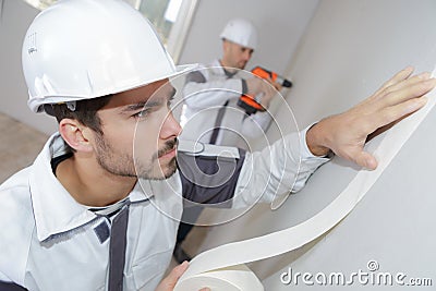 Painter worker protecting wall before painting at home improvement work Stock Photo