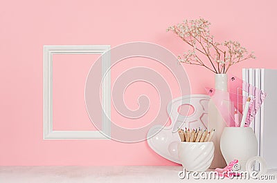 Painter workplace - wooden blank photo frame, white stationery, palette, pencils on soft pink background. Stock Photo