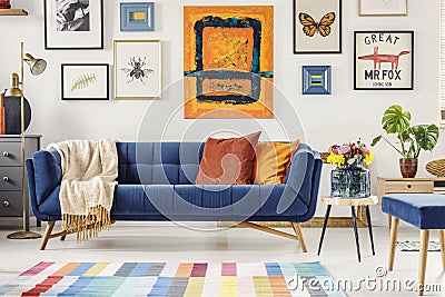 Painting above navy blue couch in artistic living room interior Stock Photo