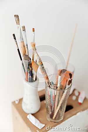 Painting brushes over white wall. Stock Photo