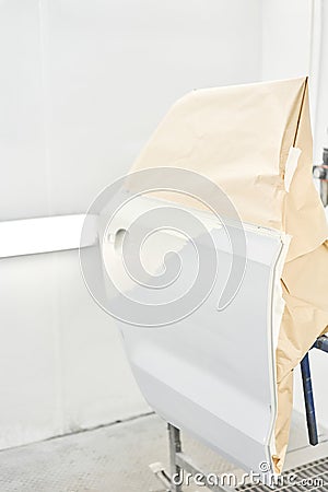 Painting the rear door of the car in special painting chamber. Car service station. Restoring a car after an accident Stock Photo