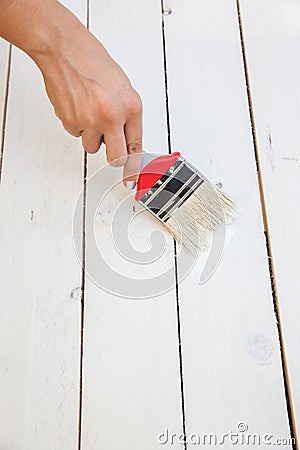 Painting on the wooden furniture with brush in hand Stock Photo