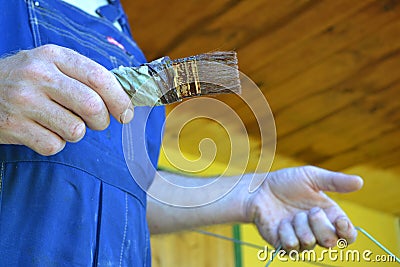 Painting the wooden surface. A man paints a paint board with a brush Stock Photo