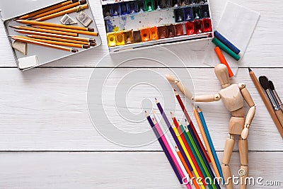 Paints and wooden painter man with brushes, object Stock Photo