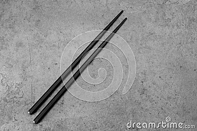 Pair of black chopsticks on concrete Stock Photo