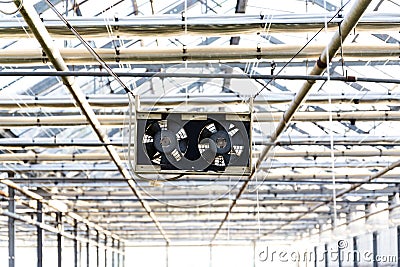 Pair of black small fans under the roof of a greenhouse, air-conditioning, heat wave concept Stock Photo