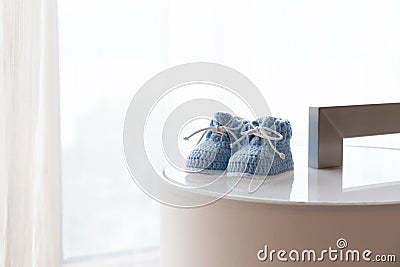 A pair of blue baby shoes against backlit window Stock Photo