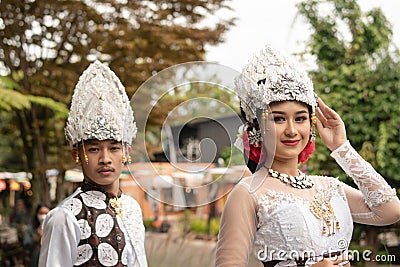 a pair of brides in white clothes standing together very intimately in a tourist park Stock Photo