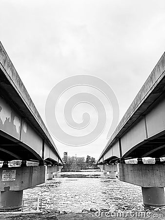 Pair of bridges crossing river leading into city Stock Photo