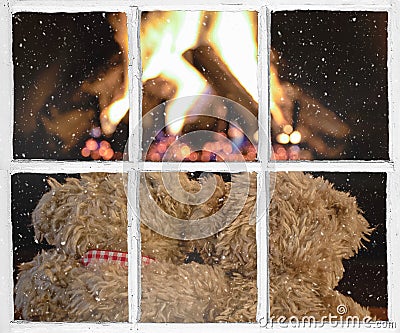Snowy windowpane with teddy bears by fireplace Stock Photo