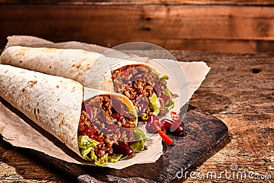 Pair of Chili Stuffed Tex Mex Wraps on Wood Table Stock Photo