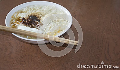 A pair of chopsticks and a bowl of noodles Stock Photo