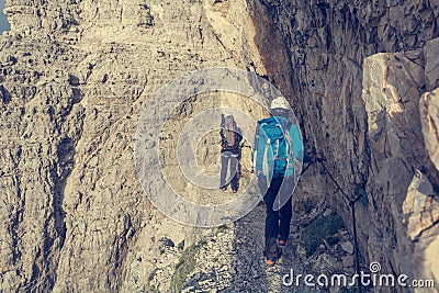 Pair of climbers walking on narrow ledge. Stock Photo
