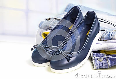 Pair female sport style flat shoes on jeans clothes background. Stock Photo