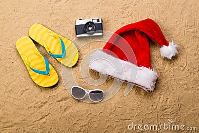 Pair of flip flop sandals, sunglasses, Santa hat and camera. Stock Photo