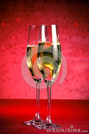 A pair of flutes of champagne on red abstract background Stock Photo