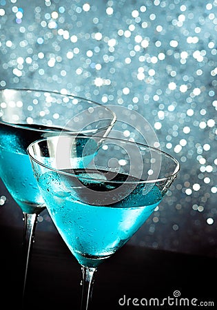 A pair of glasses of fresh blue cocktail with ice on bar table Stock Photo