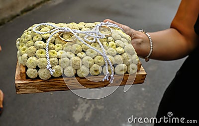 Pair of gold wedding bands arranged on a bed of creamy flowers. Stock Photo
