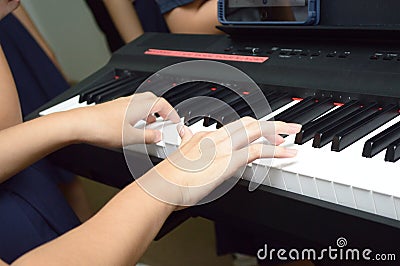 A pair of hands playing a musical keyboard piano organ instrument Stock Photo