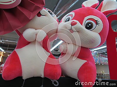 A pair of identical similar same red white rabbit soft toy plushies on display Stock Photo