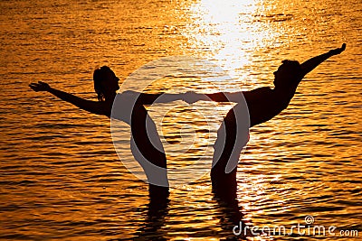 Pair keeps for hands in sea on sunset Stock Photo