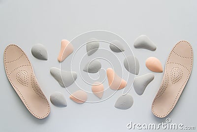 A pair of leather orthopedic insoles surrounded by components. Pelots for unloading the cross arch of different shapes and sizes. Stock Photo