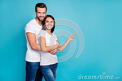 Pair in love standing piggy back indicating on crazy sale wear casual outfit isolated blue background Stock Photo